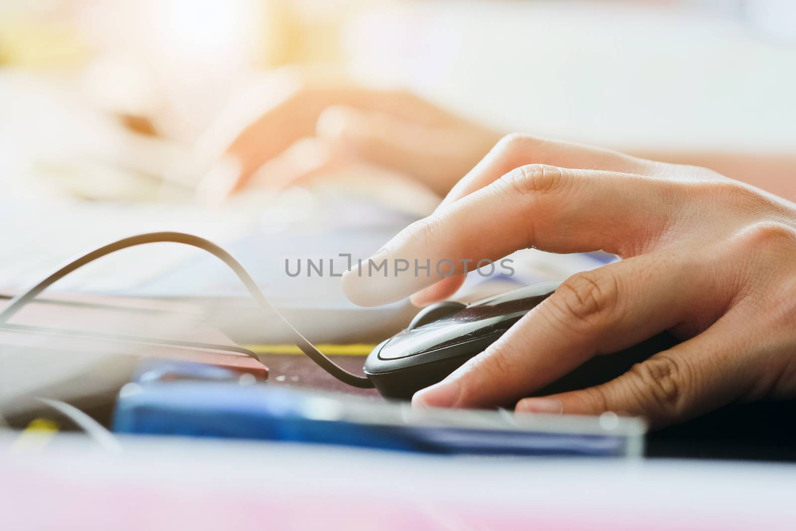 Close-up of female hands using laptop computer, working on laptop with flare light background. Searching Internet ,Businesswoman working at home office