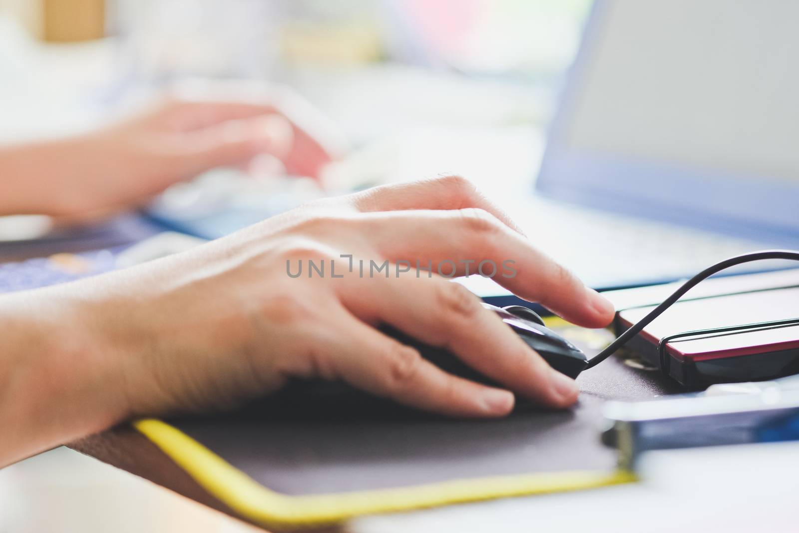Close-up of female hands using laptop computer, working on laptop with flare light background. Searching Internet ,Businesswoman working at home office