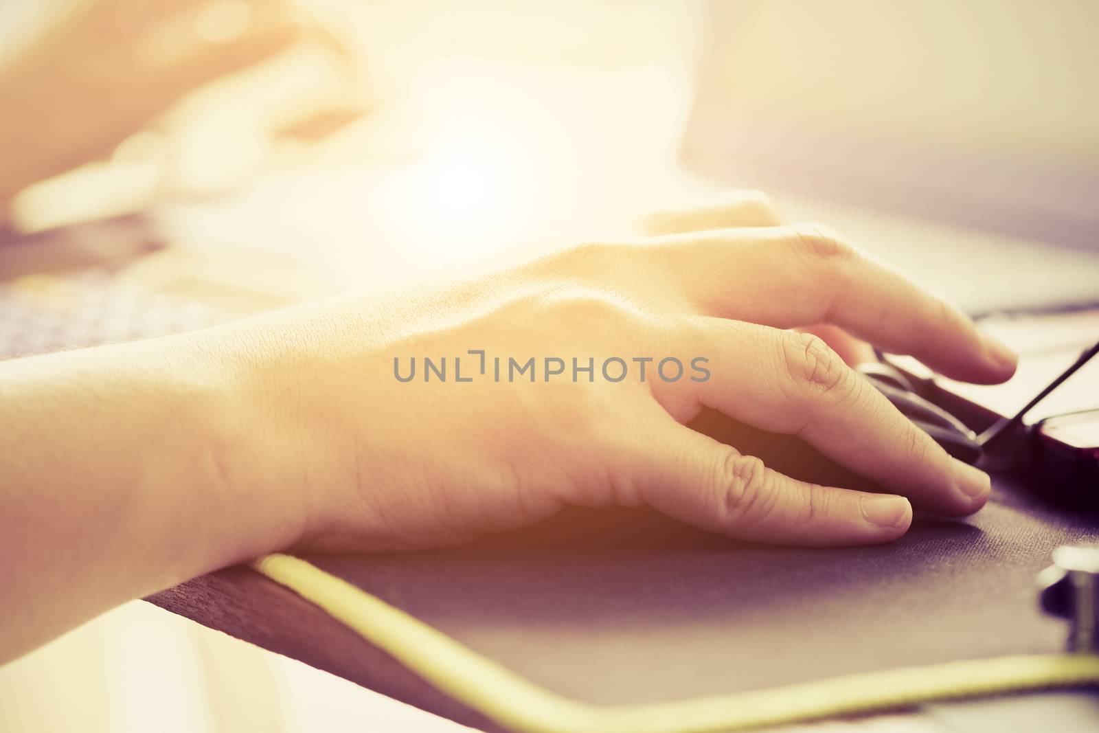 Close-up of female hands using laptop computer, working on laptop with flare light background. Searching Internet ,Businesswoman working at home office