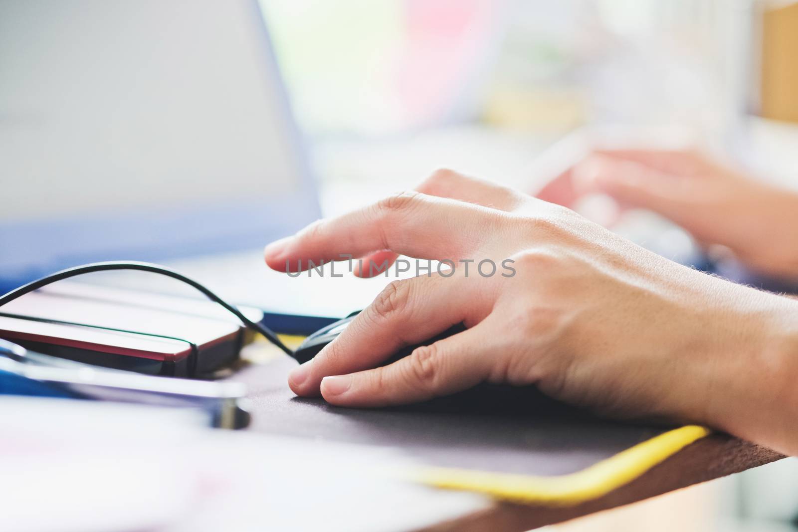 Close-up of female hands using laptop computer, working on laptop with flare light background. Searching Internet ,Businesswoman working at home office
