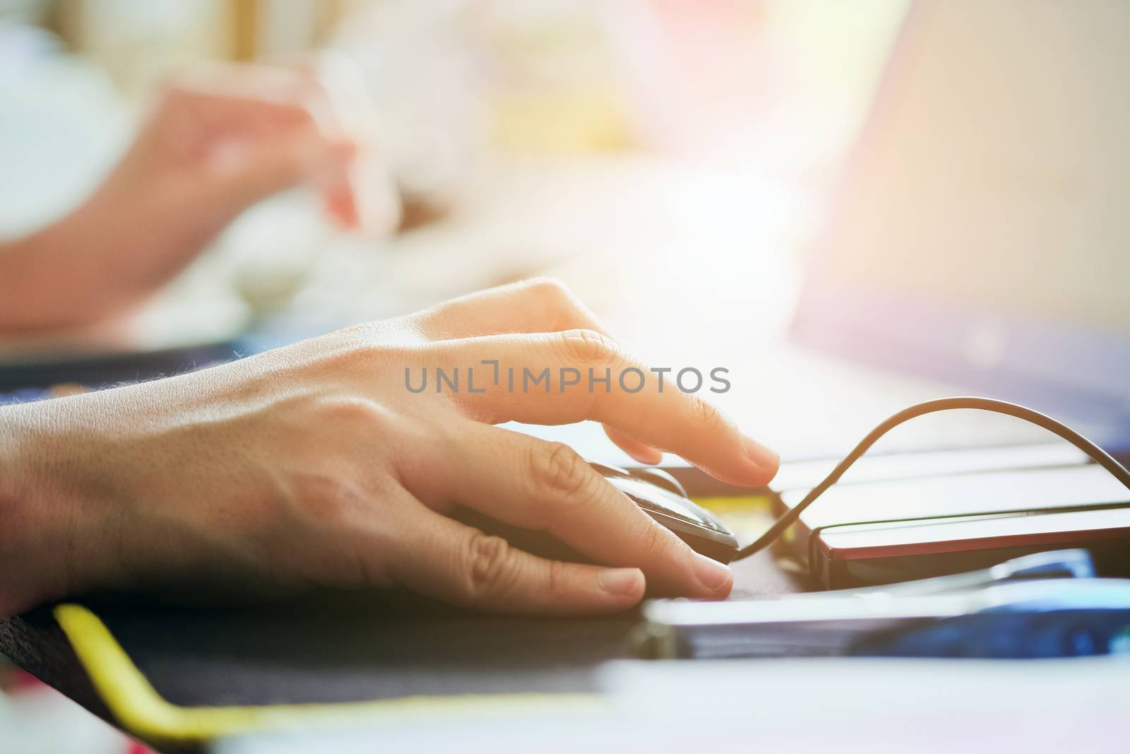Close-up of female hands using laptop computer, working on laptop with flare light background. Searching Internet ,Businesswoman working at home office