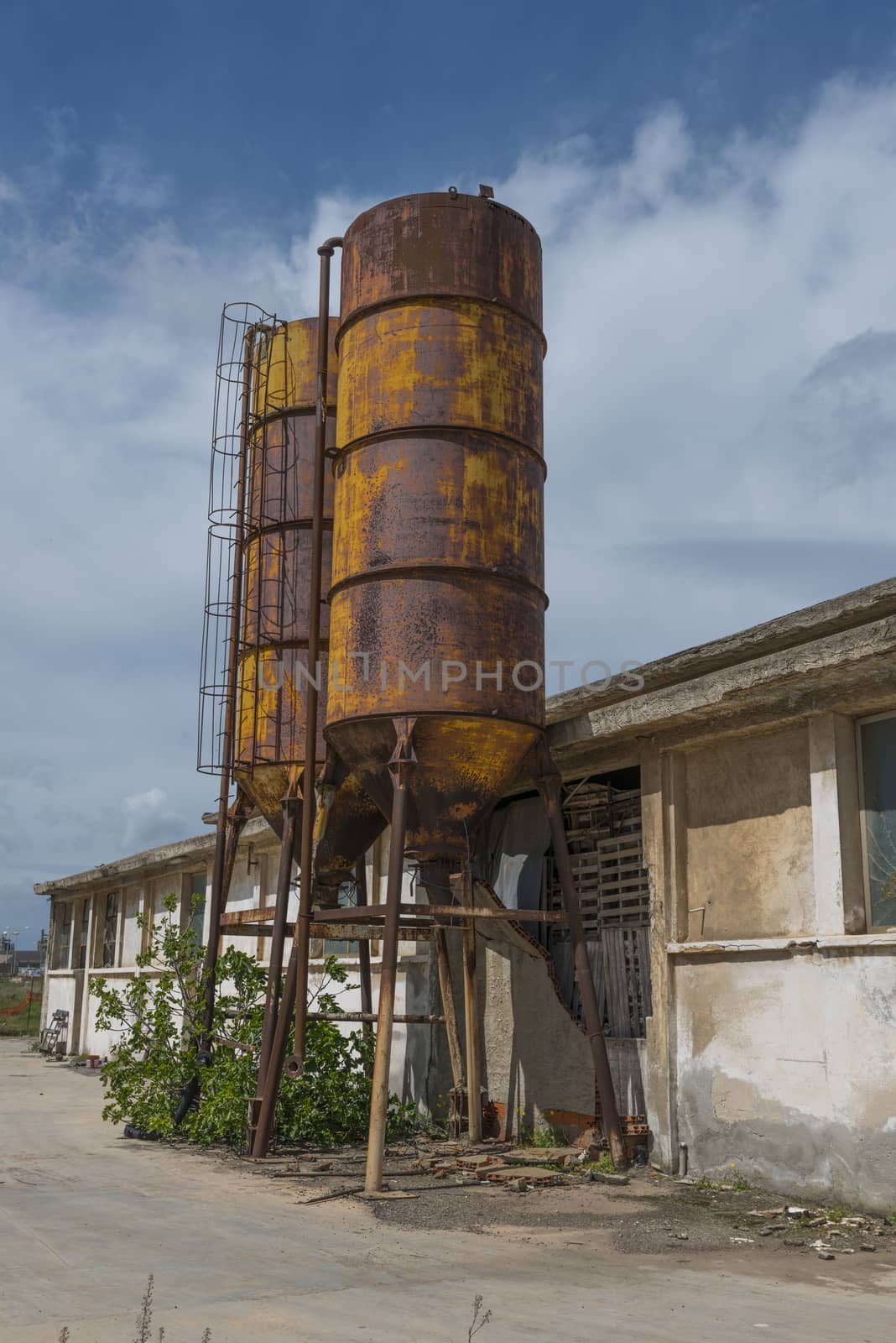 old abandonned industry with old rusted barrels in the north of sardinia the italian island near porte torres