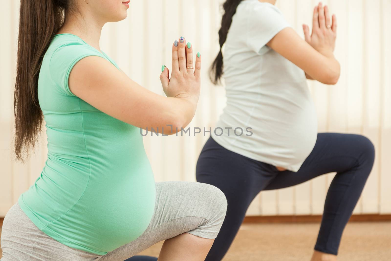 Beautiful pregnant women doing yoga in the gym