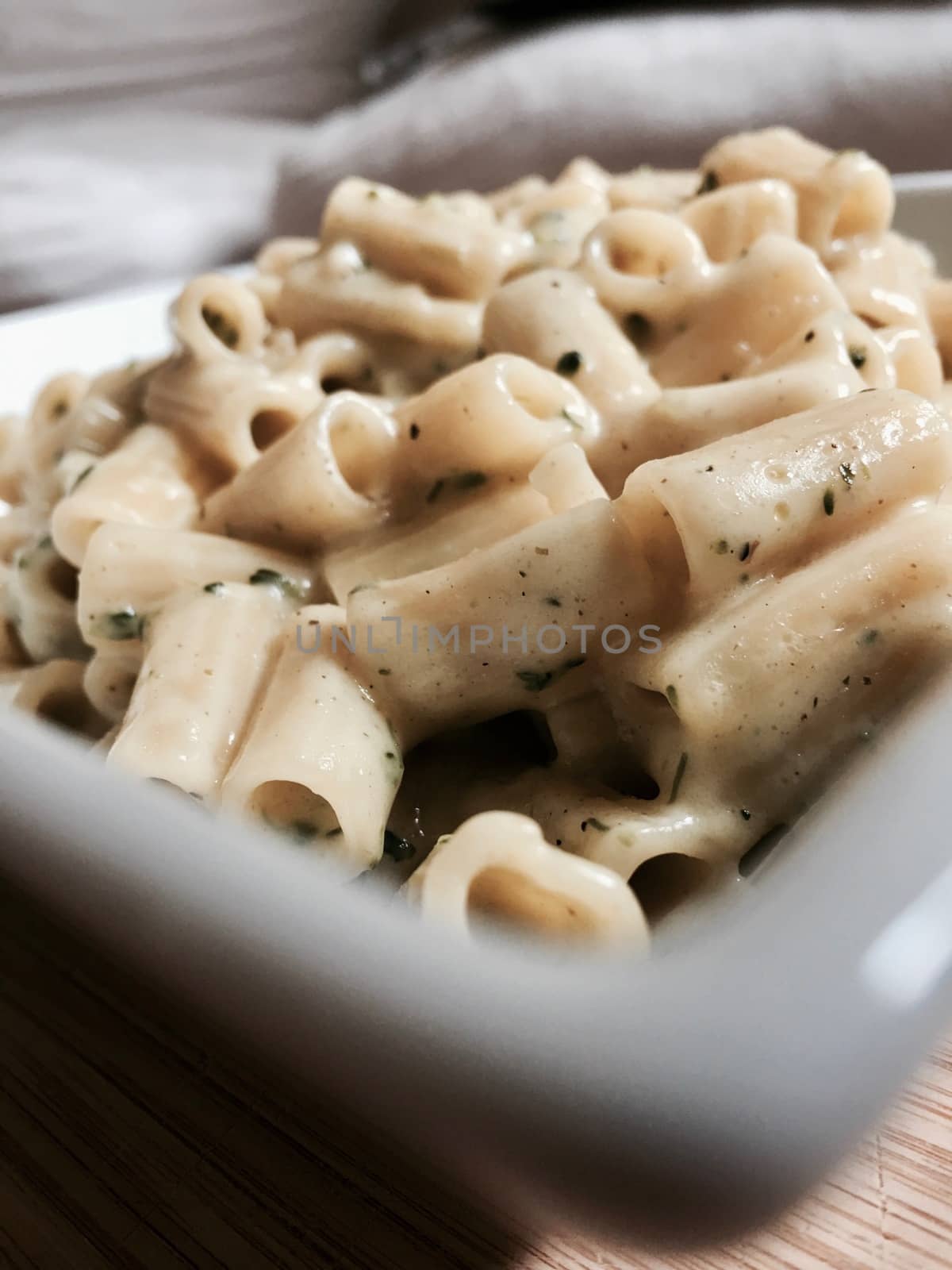 Tasty pasta with broccoli and chives on wooden board at home.