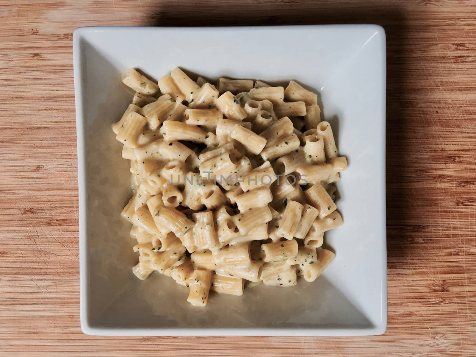 Delicious broccoli pasta in square plate on the wooden board at home. Food concept.