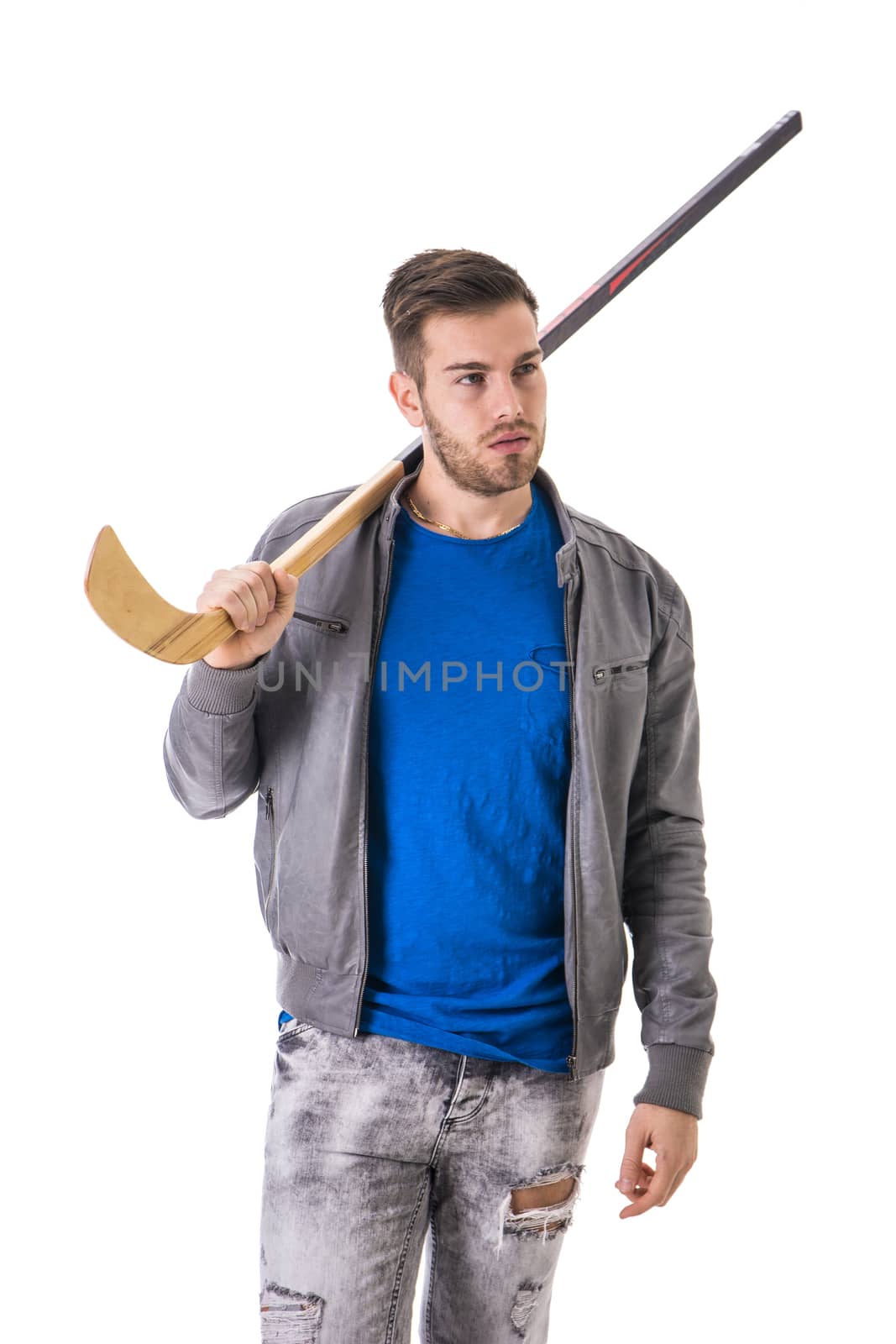 Portrait of a handsome man posing for camera with hockey stick behind his neck