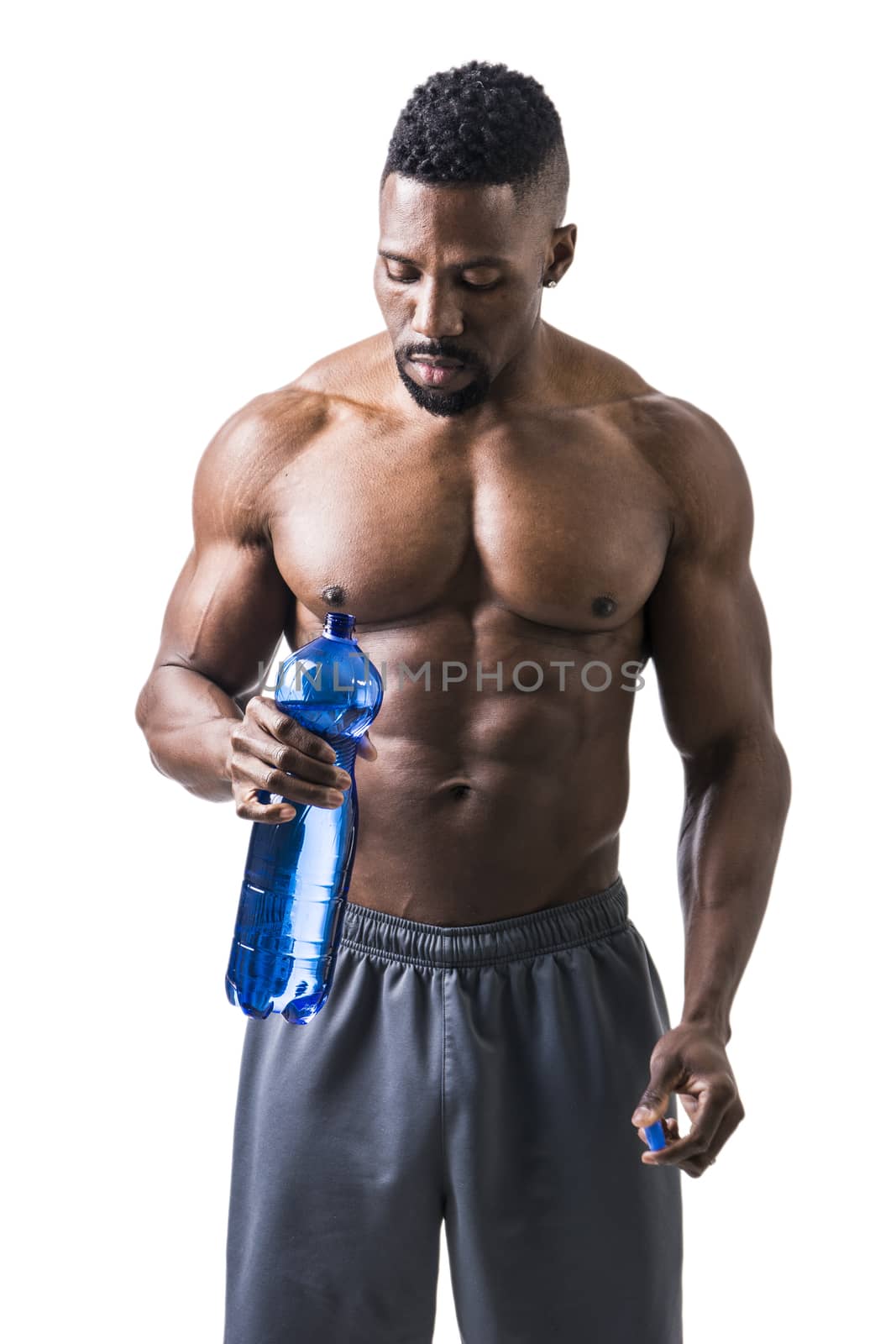Muscular shirtless black male bodybuilder drinking water from plastic bottle. Isolated on white, looking up