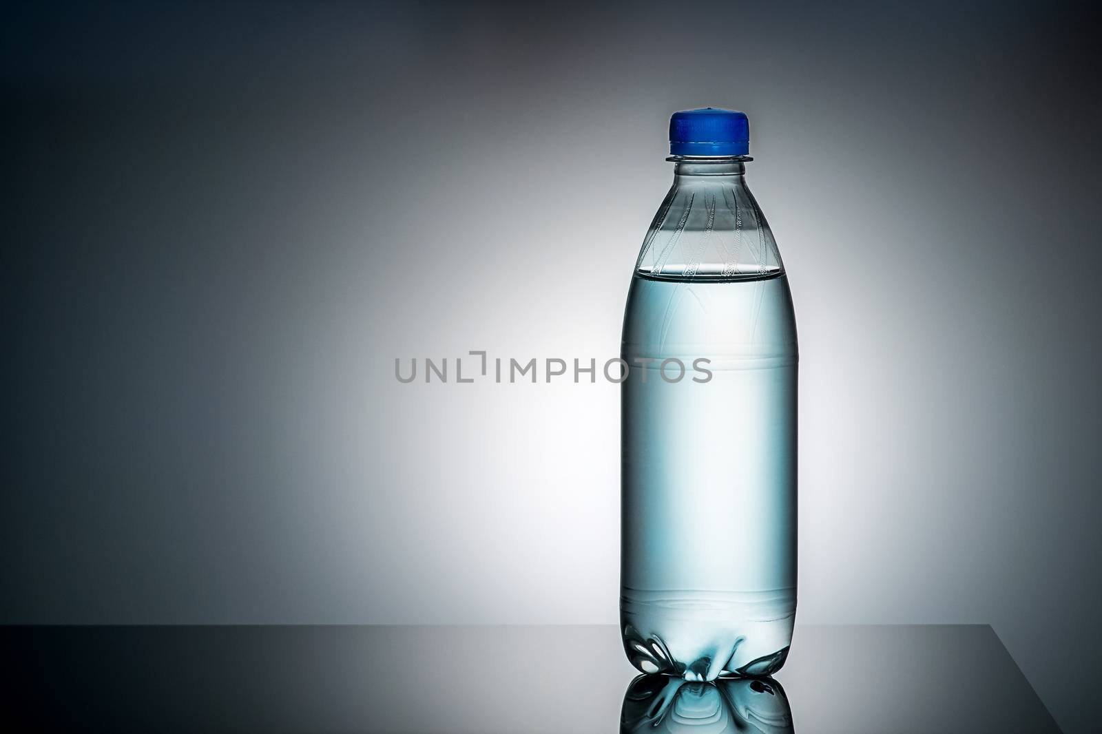 Plastic bottle with water. Gradient background. Mirror reflection