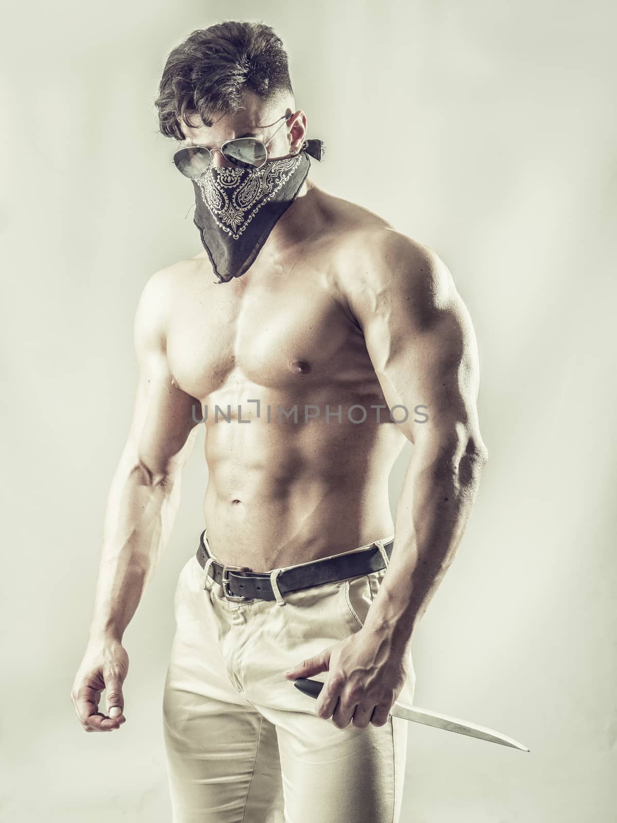 Handsome muscular young man with mask over face as a robber or bandit