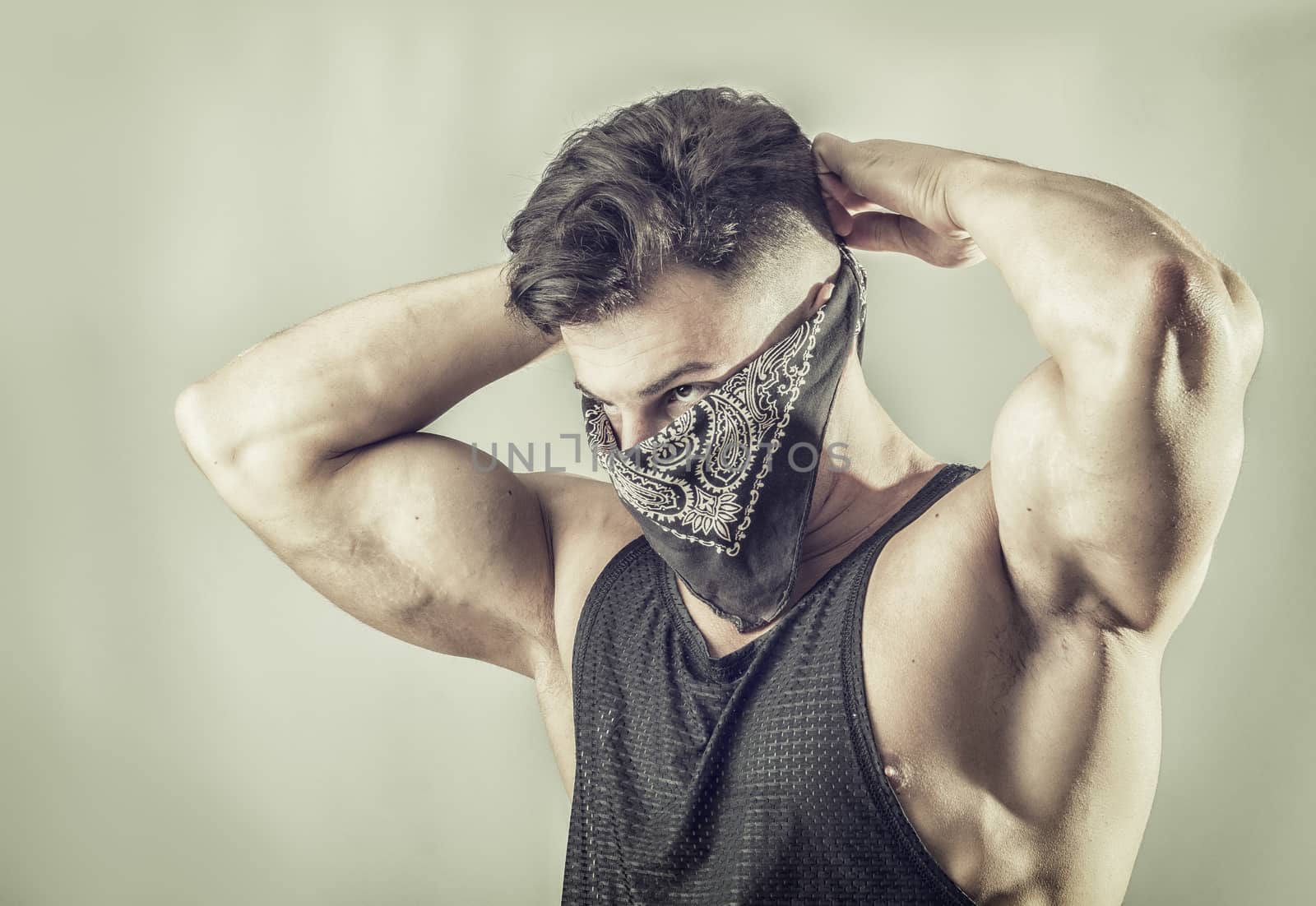 Handsome muscular young man with mask over face as a robber or bandit
