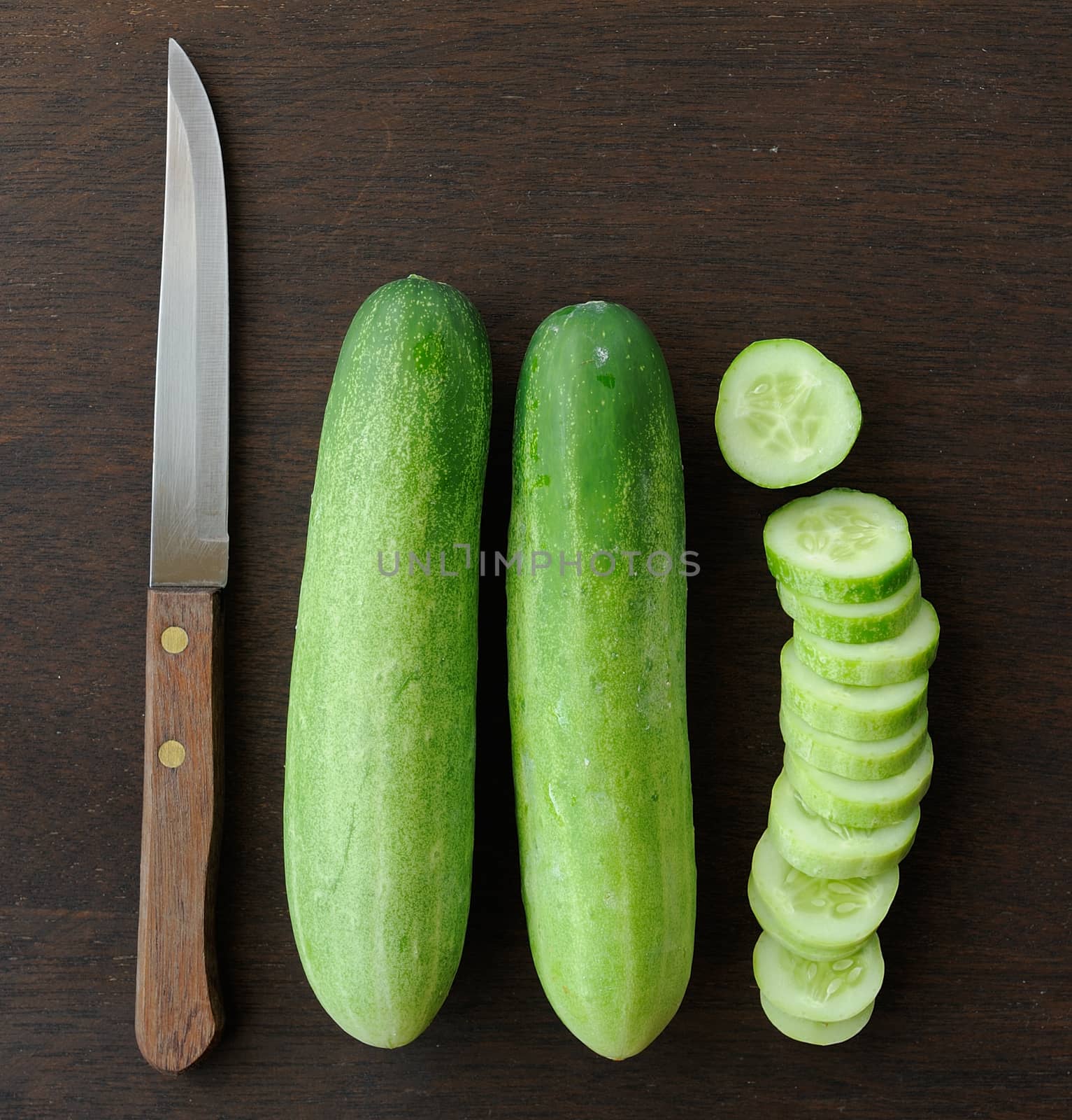 cucumber slices and  Knife on wooden background