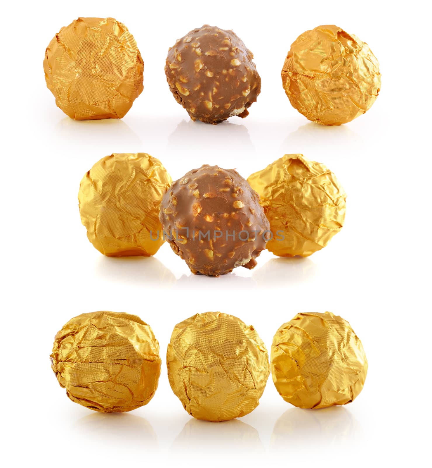 Sweet chocolate candy wrapped in golden foil isolated on white b by sommai