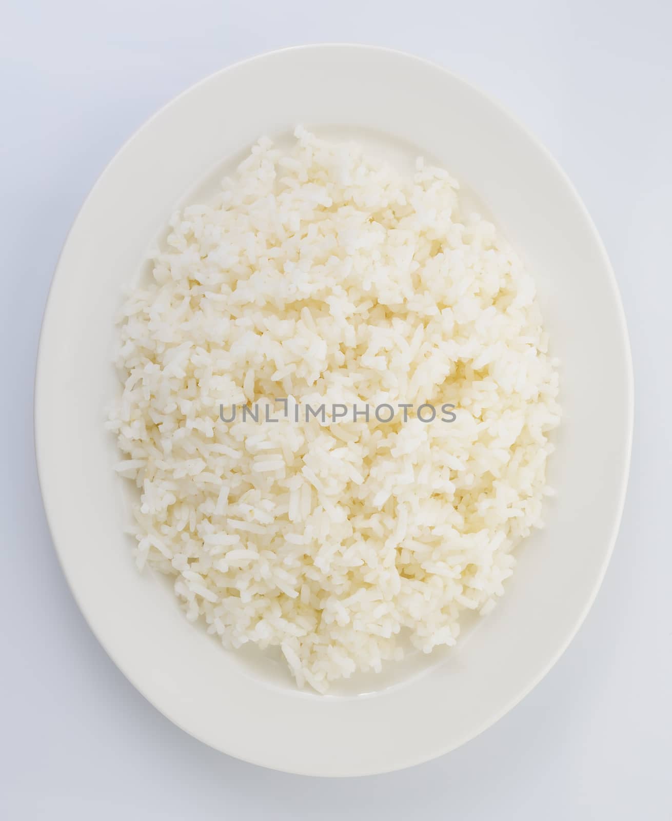 Cooked rice in a white plate on white background