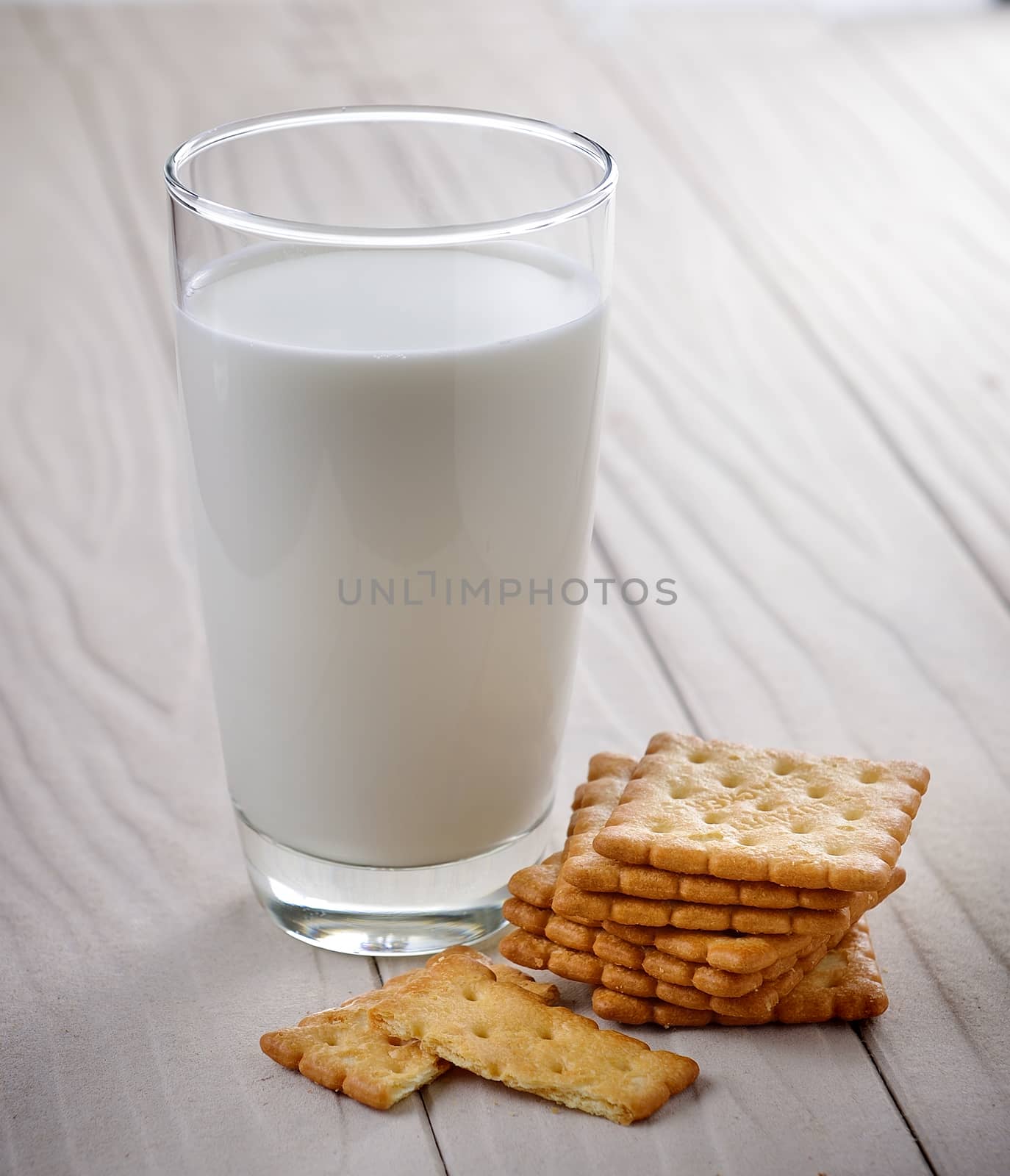 glass of milk and cracker on whitewood