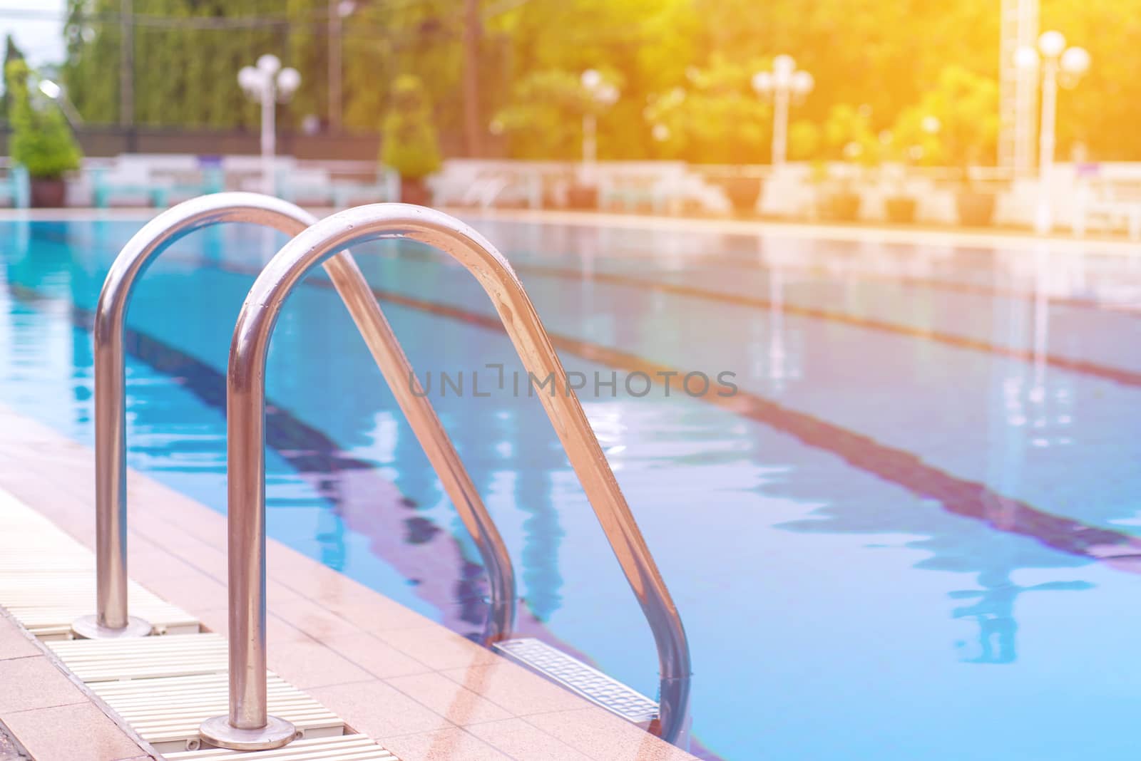 blue swimming pool at hotel with stair.