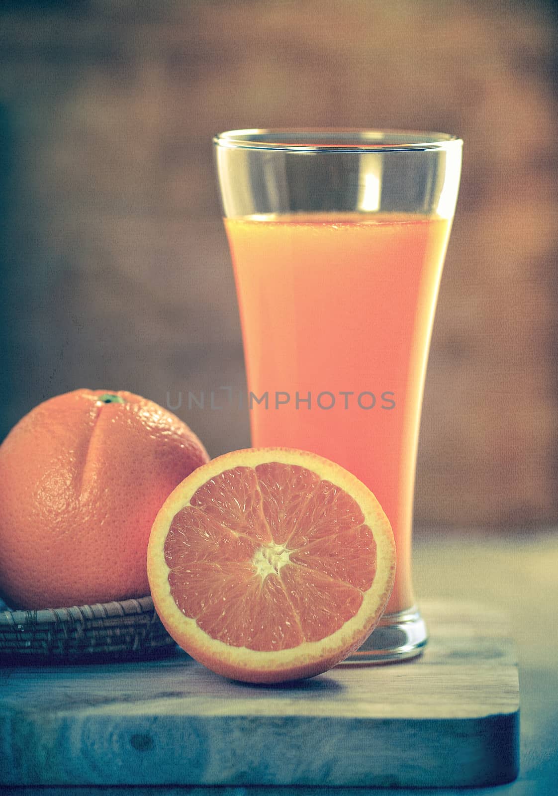 Orange juice glass and fresh oranges on wood. Photo in retro style