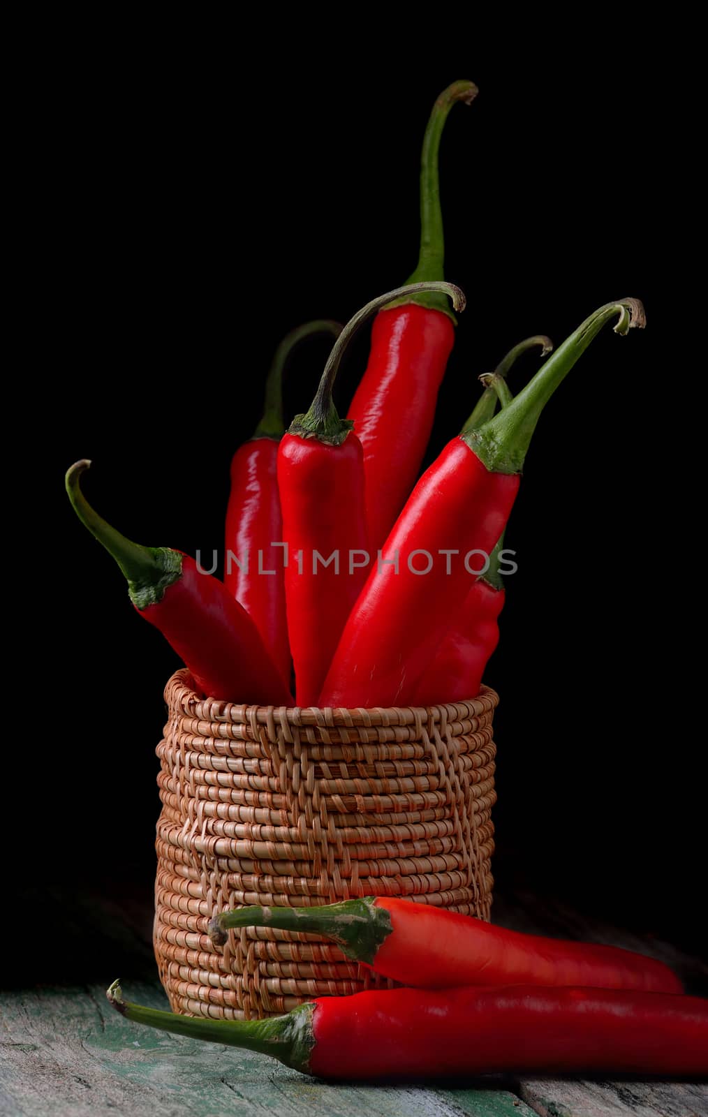 basket full of red chili peppers on wood  by sommai