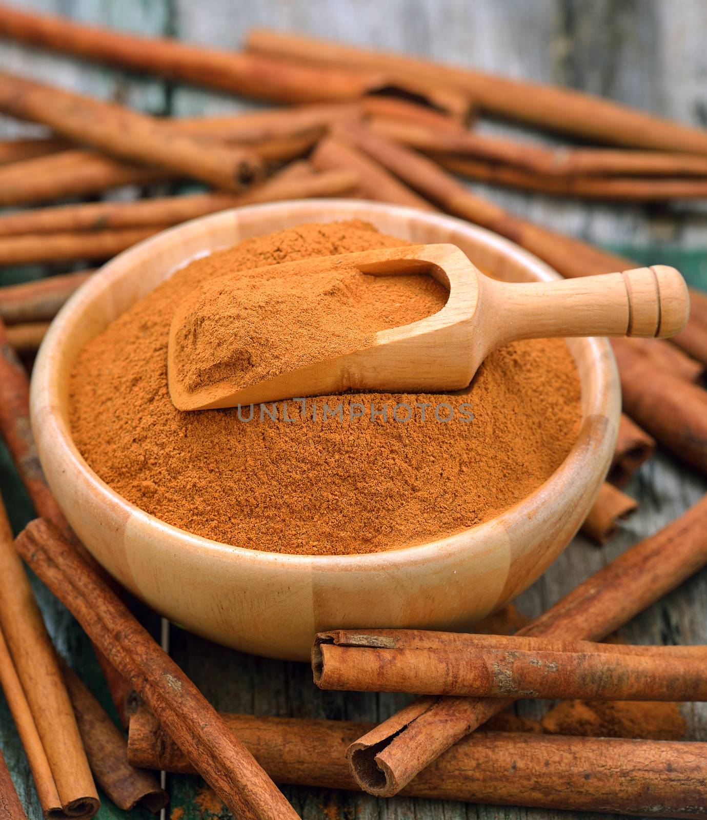 Cinnamon sticks and powder cinnamon in the bowl on table by sommai