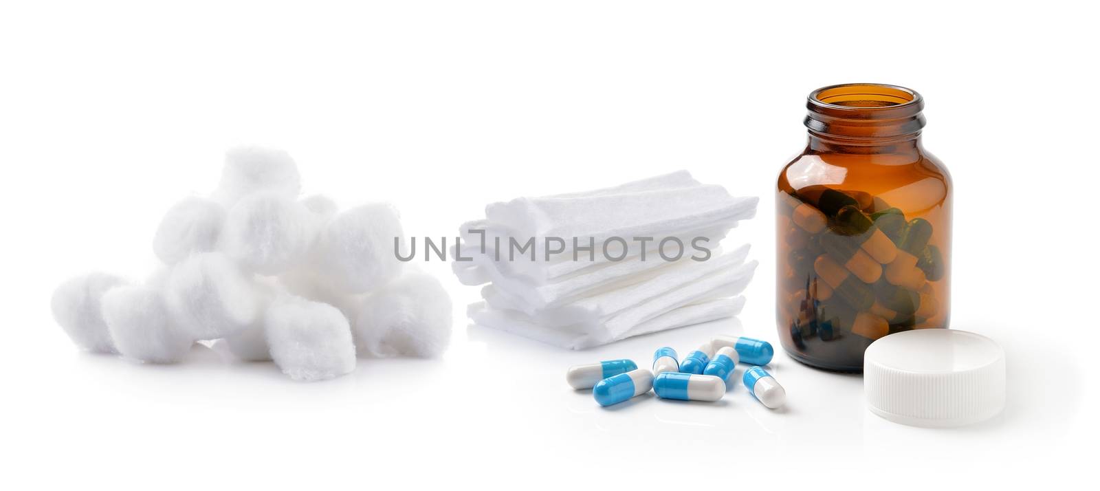 pills out of bottle and Cotton wool bandage on white background