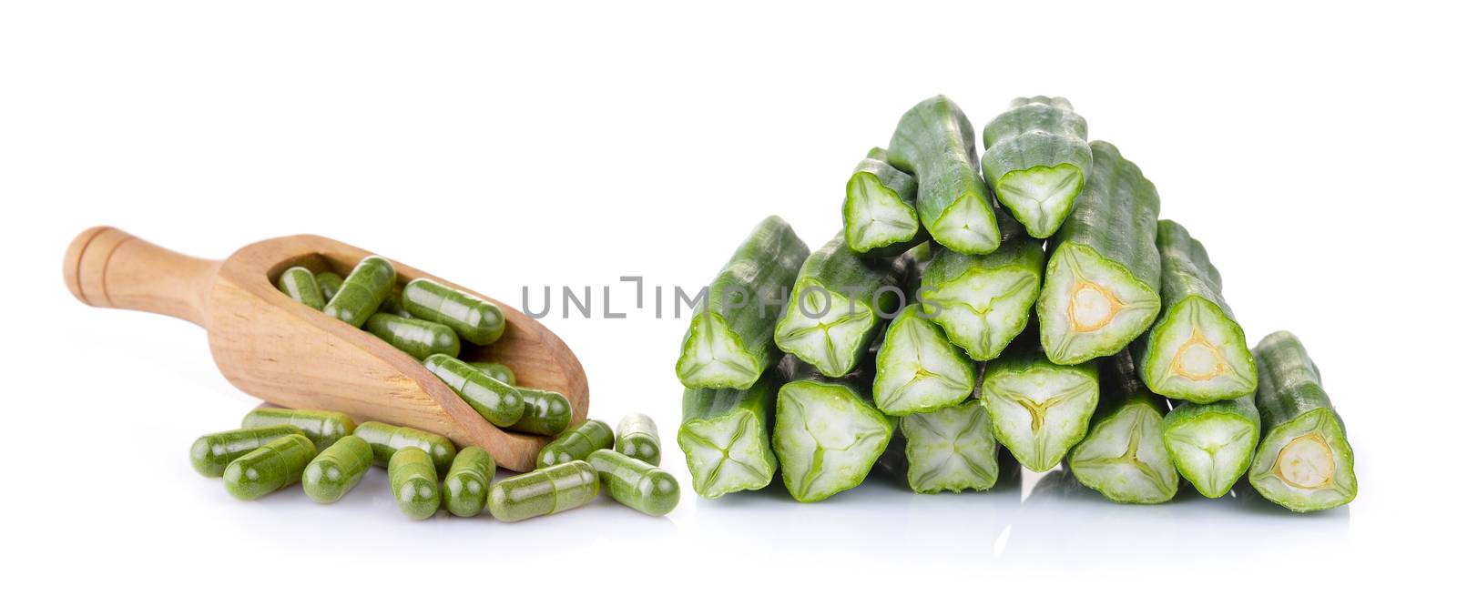 Moringa capsules and moringa in the scoop on white background by sommai