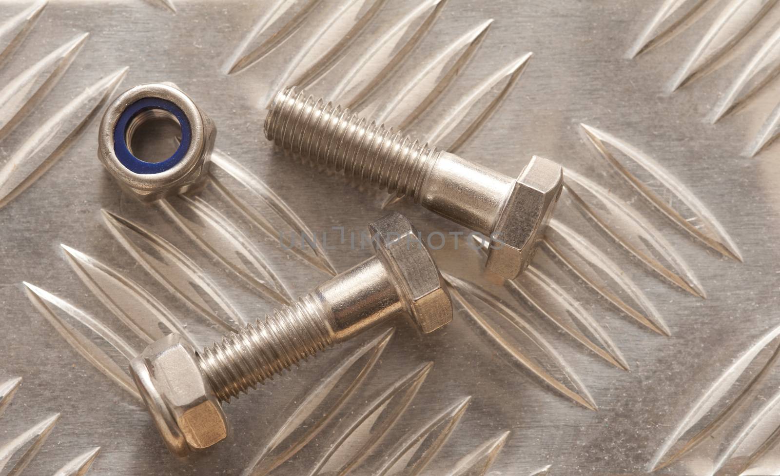 Precision Engineering Concept, Close-up view of two nut bolts over shiny anti-slip stainless steel metal surface
