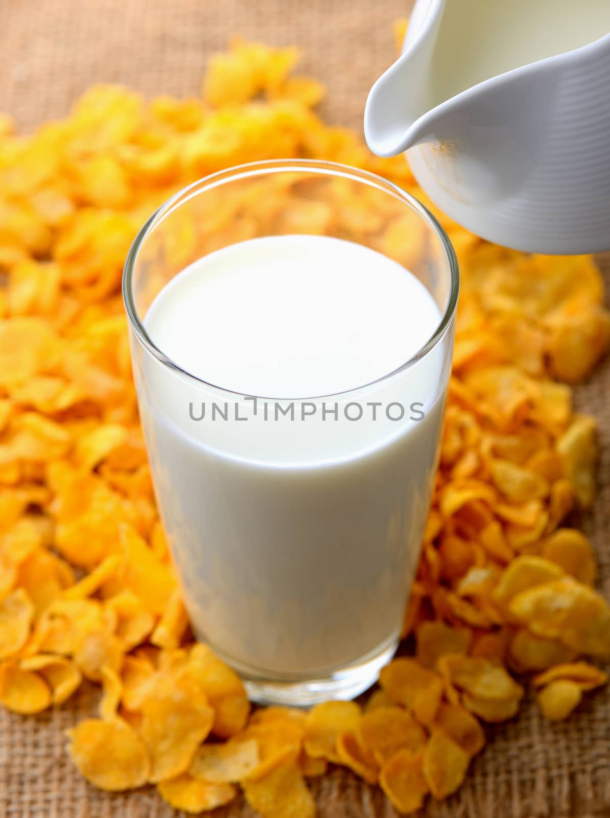 glass of milk and cereals on the wooden table by sommai