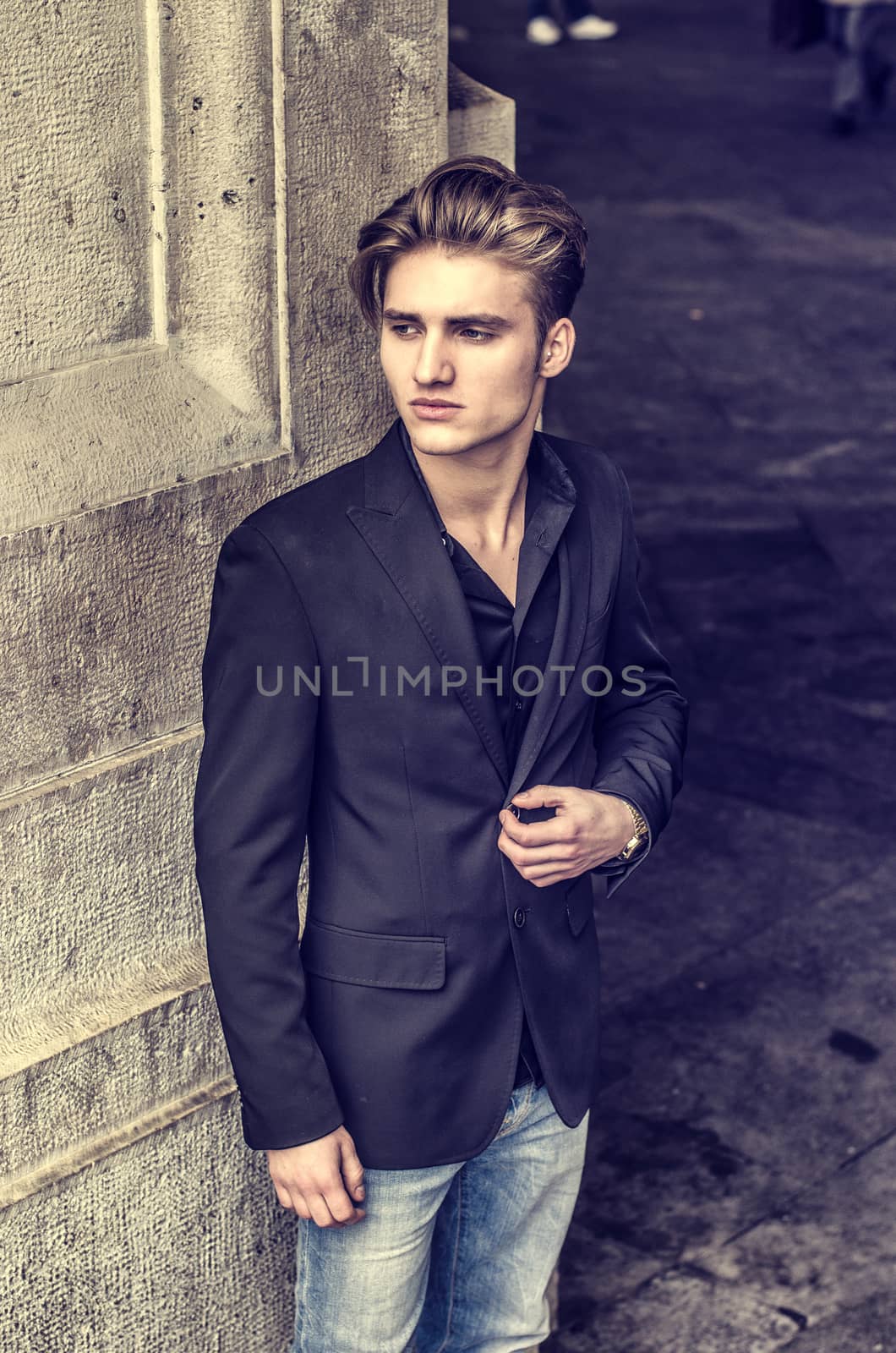 Attractive blue eyed, blond young man leaning against white wall by artofphoto