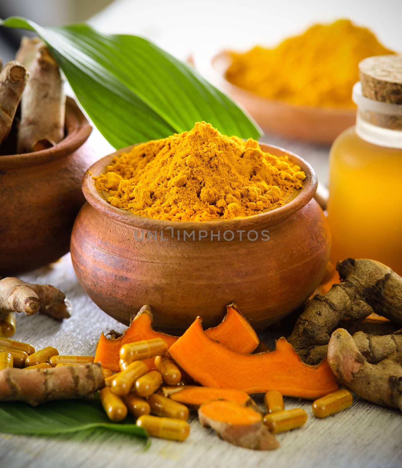 Turmeric powder and turmeric capsules on wooden background by sommai