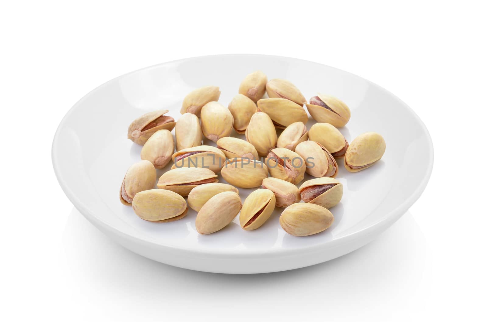 pistachios in plate on white background