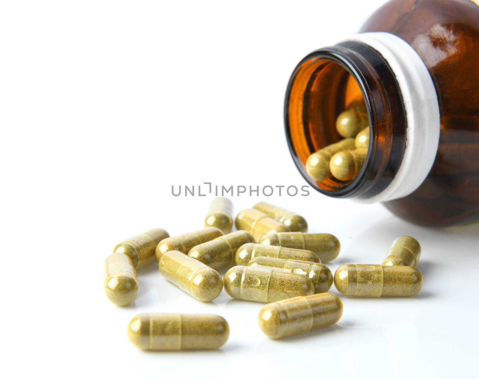 Herbal Capsules in bottle on white background by sommai