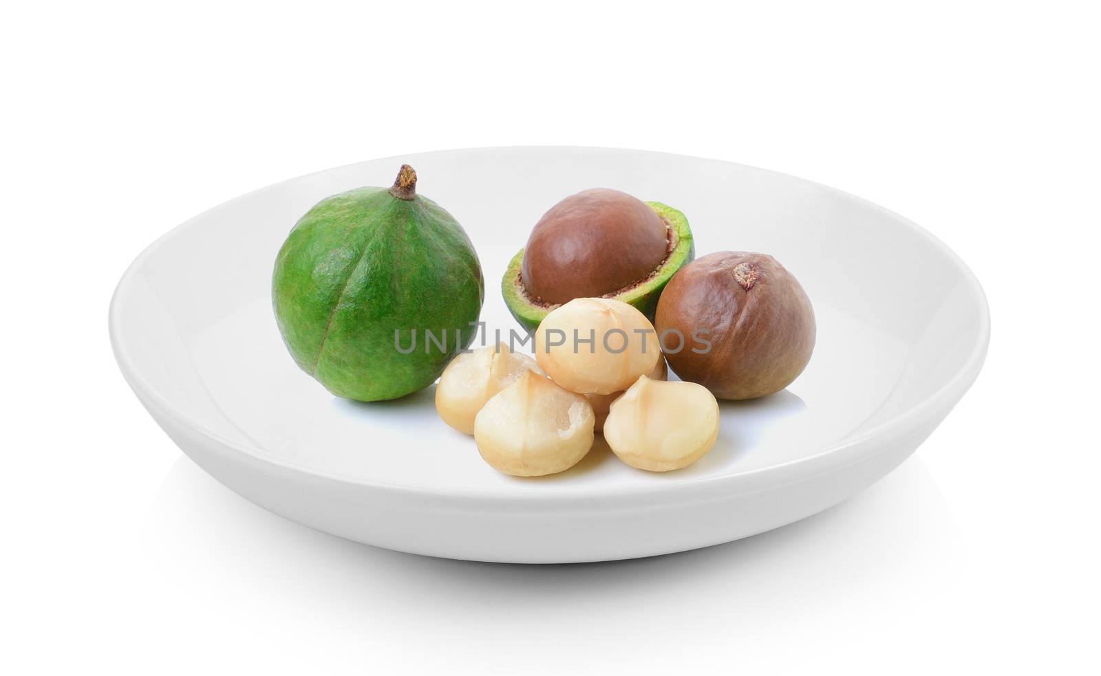 macadamia nuts in plate on white background by sommai
