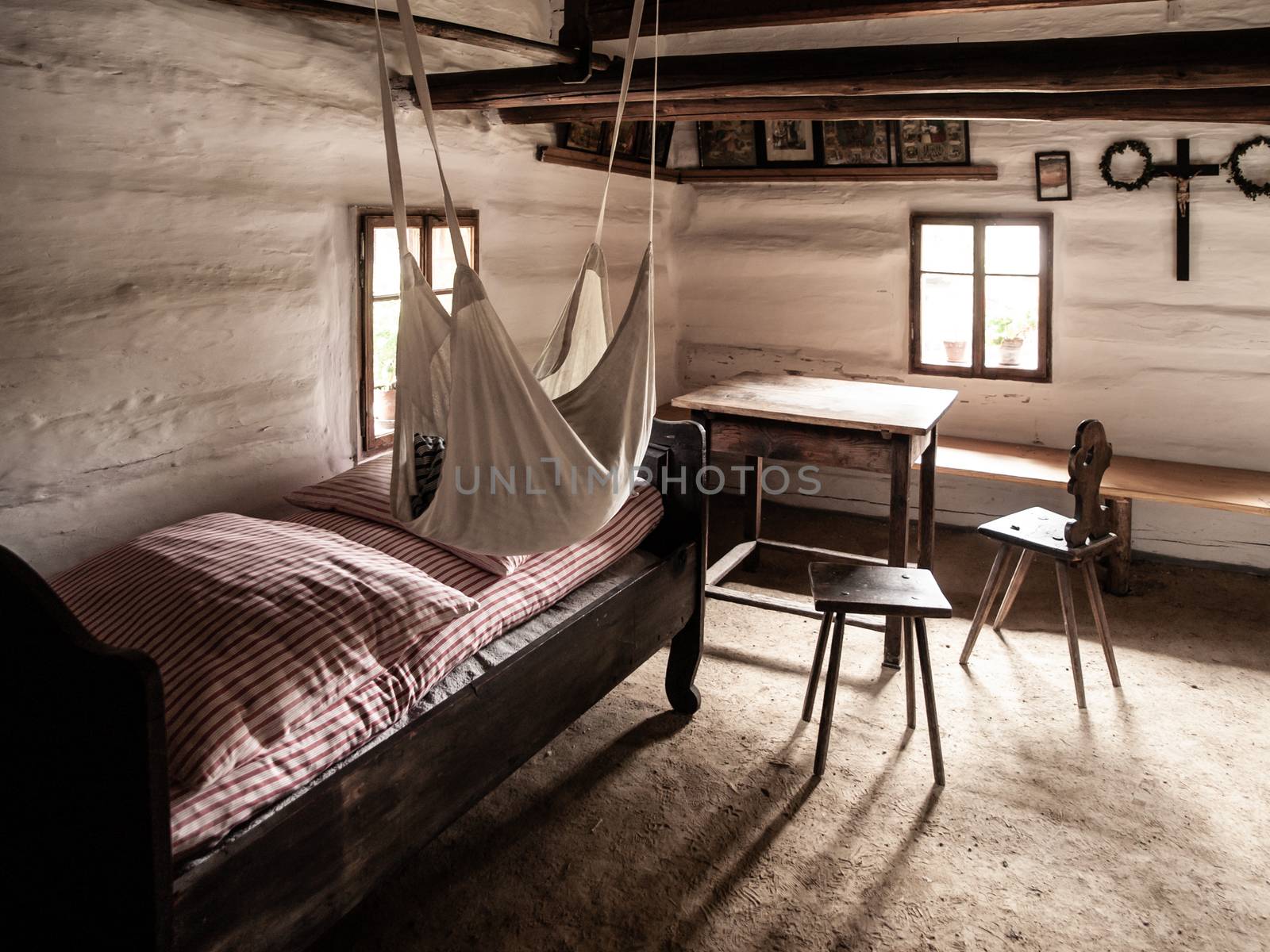 Vintage room with bed, table and chairs in old rural house. Sepia style image by pyty