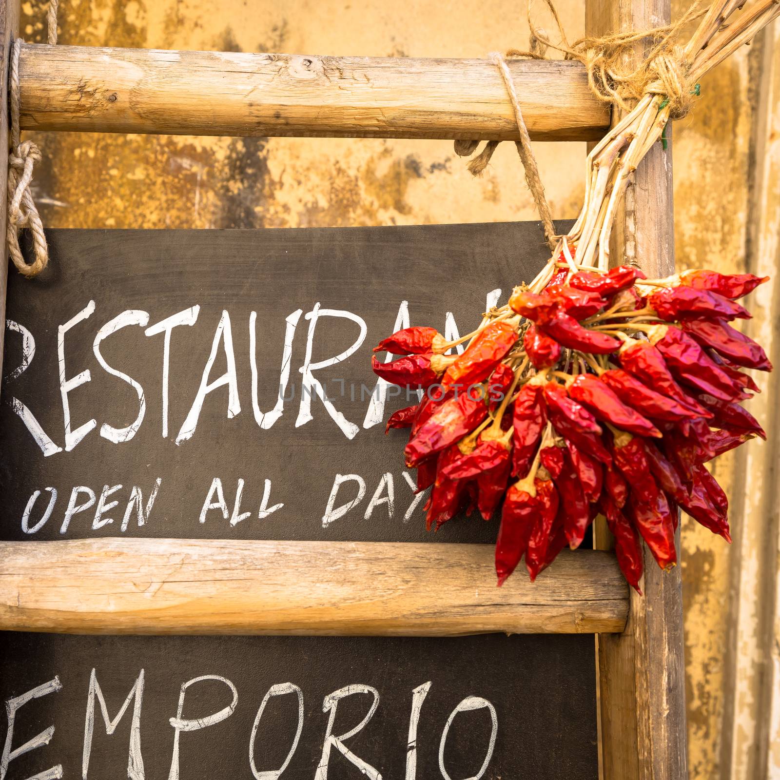 Italy, Puglia Region. Traditional restaurant blackboard with red peppers.