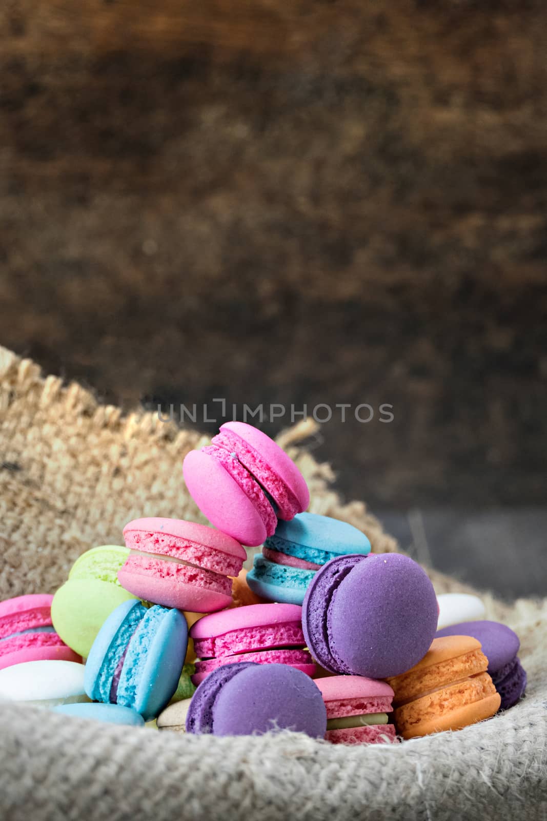 colorful of macarons on a sack over wooden table