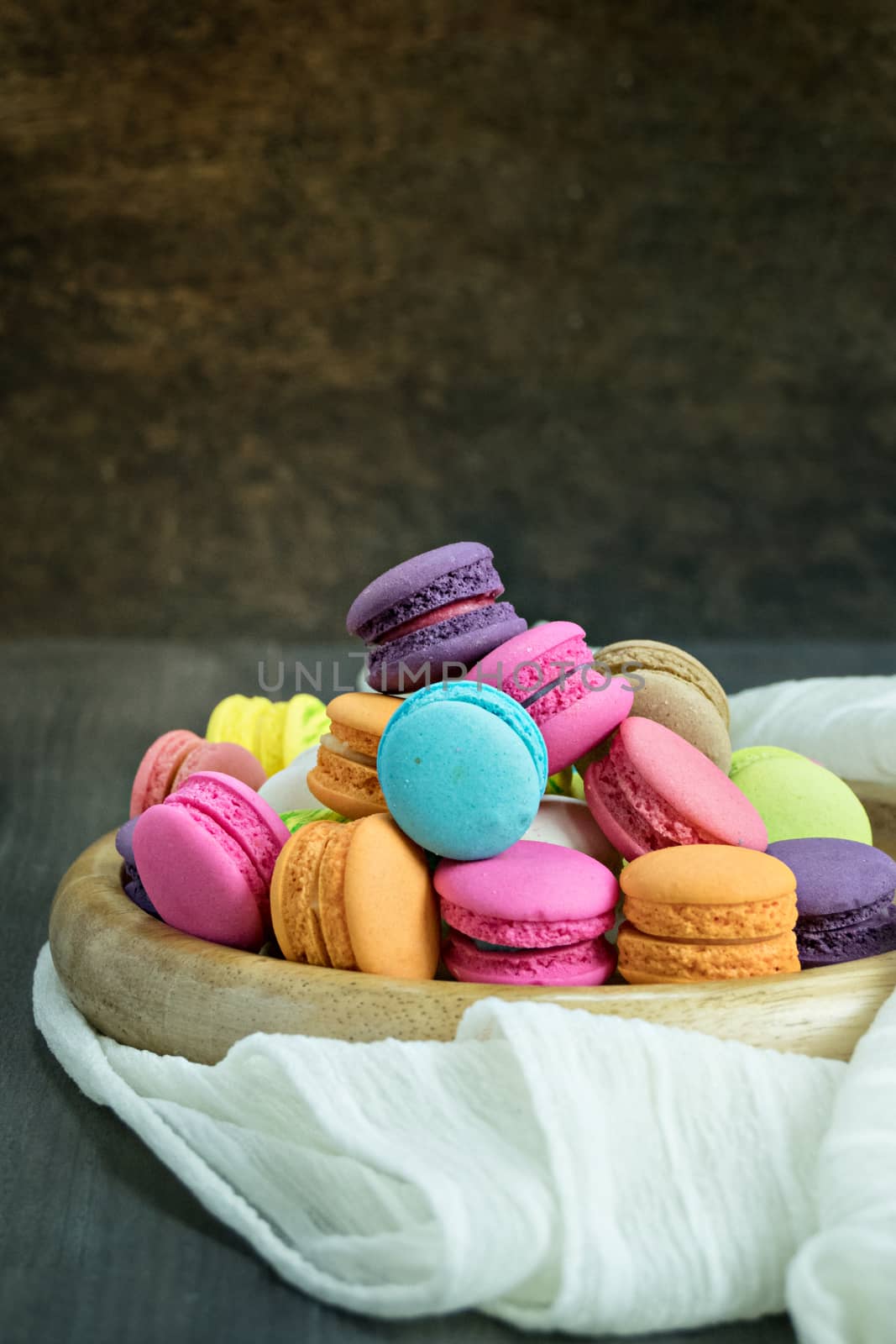 colorful of macarons on plate over wooden table