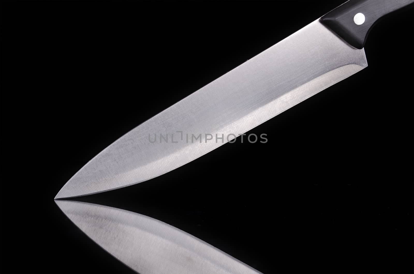 Close up view of a kitchen knife over black isolated background