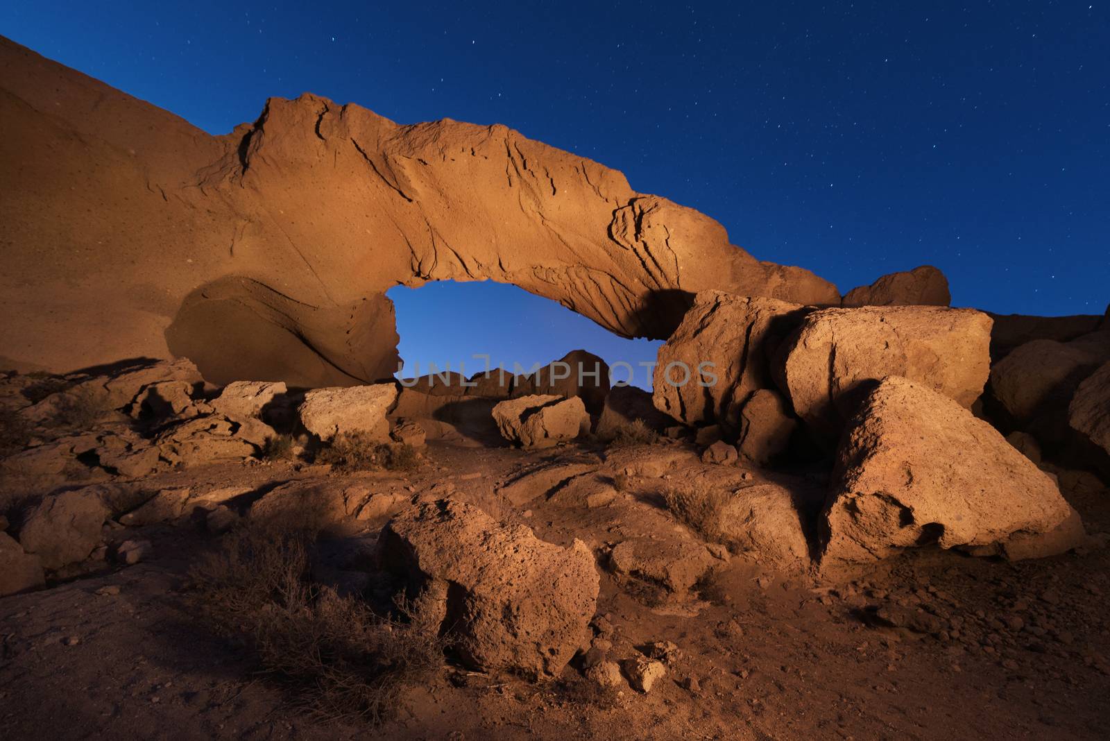 Starry night landscape of a volcanic Rock arch in Tenerife, Canary island, Spain. by HERRAEZ