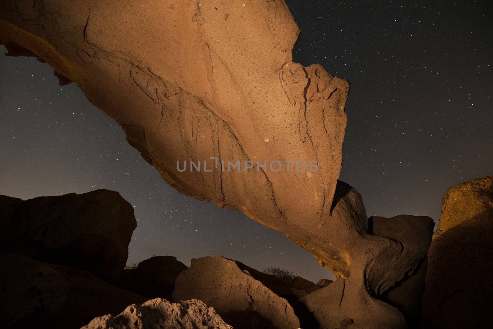 Starry night landscape of a volcanic Rock arch in Tenerife, Canary island, Spain. by HERRAEZ