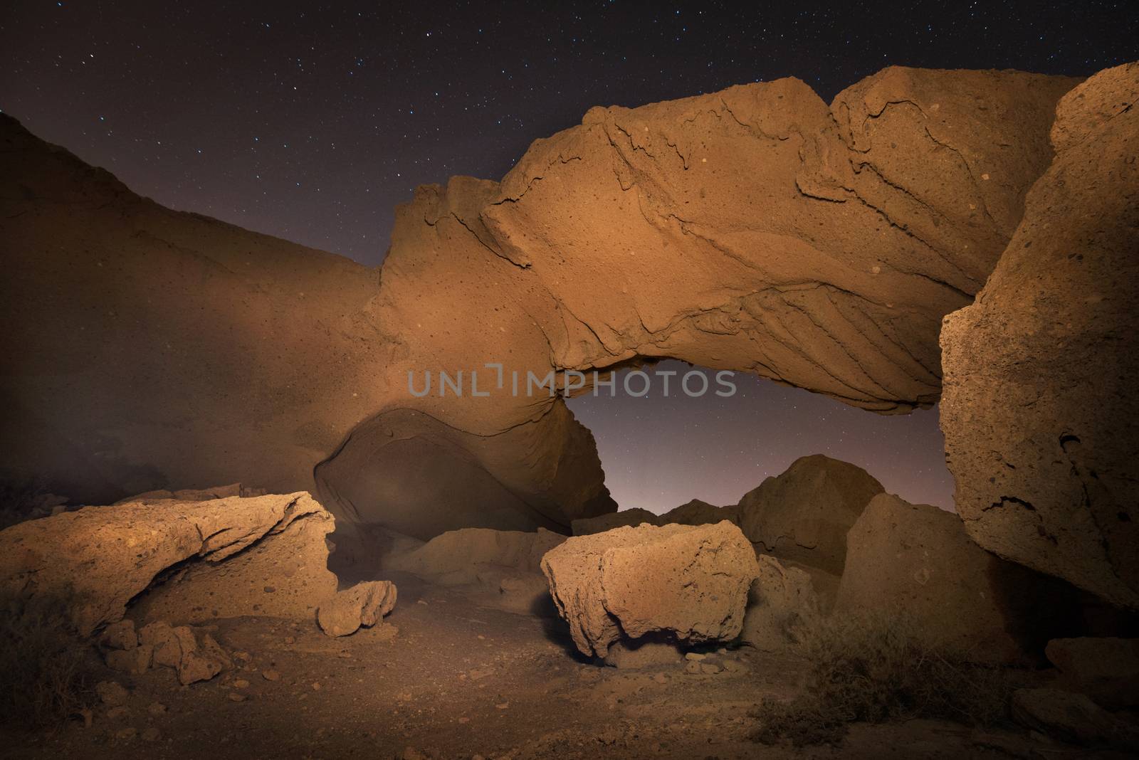 Starry night landscape of a volcanic Rock arch in Tenerife, Canary island, Spain. by HERRAEZ