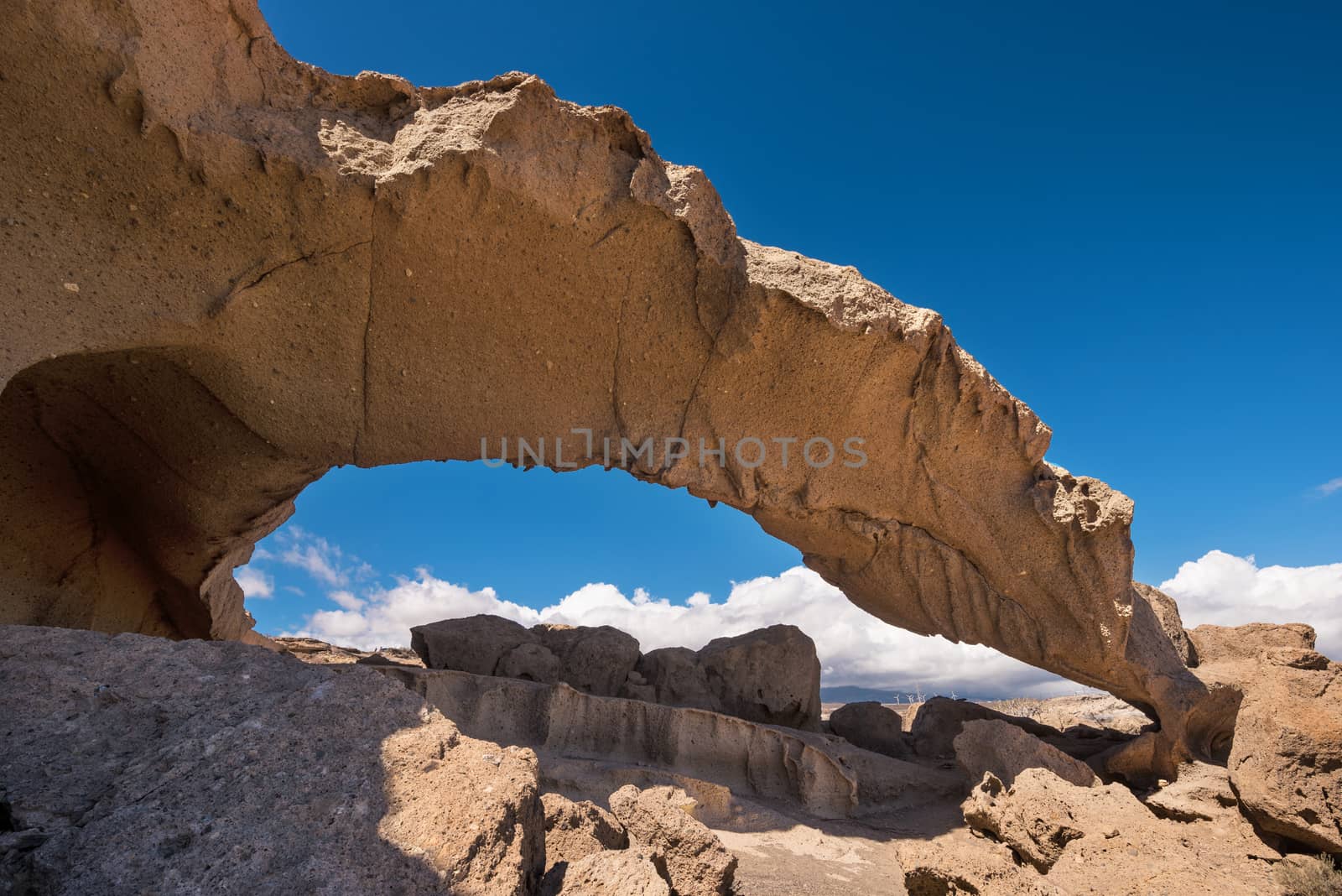 Natural volcanic rock arch formation in desertic landscape in Tenerife, Canary islands, Spain. by HERRAEZ