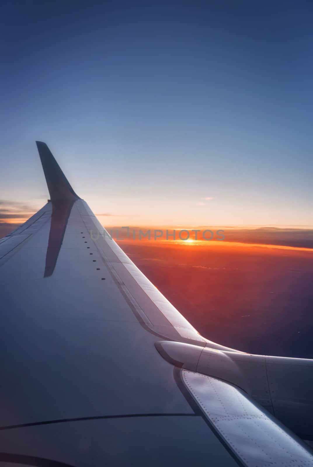 Airplane wing during a vibrant sunset