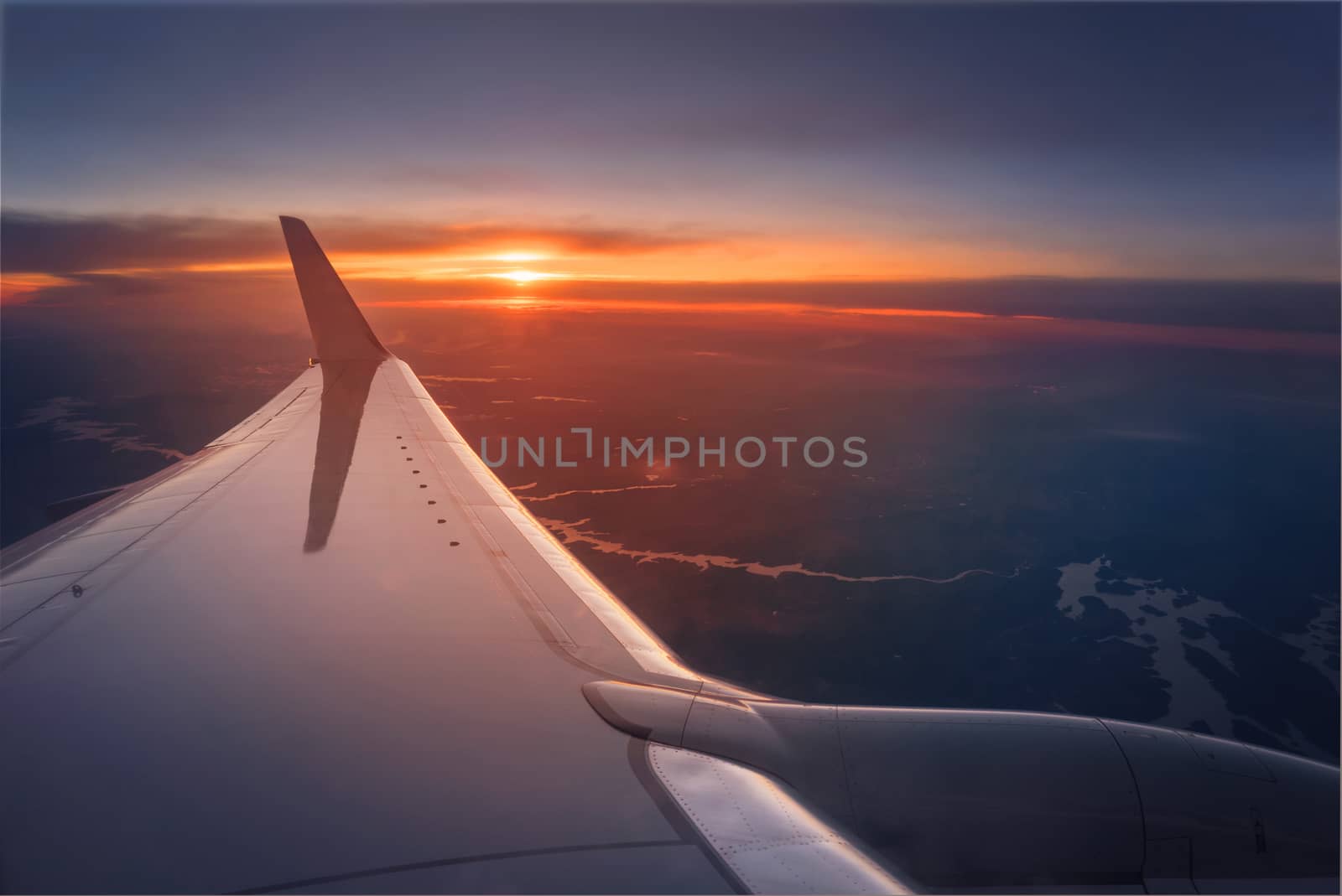 Airplane wing during a vibrant sunset