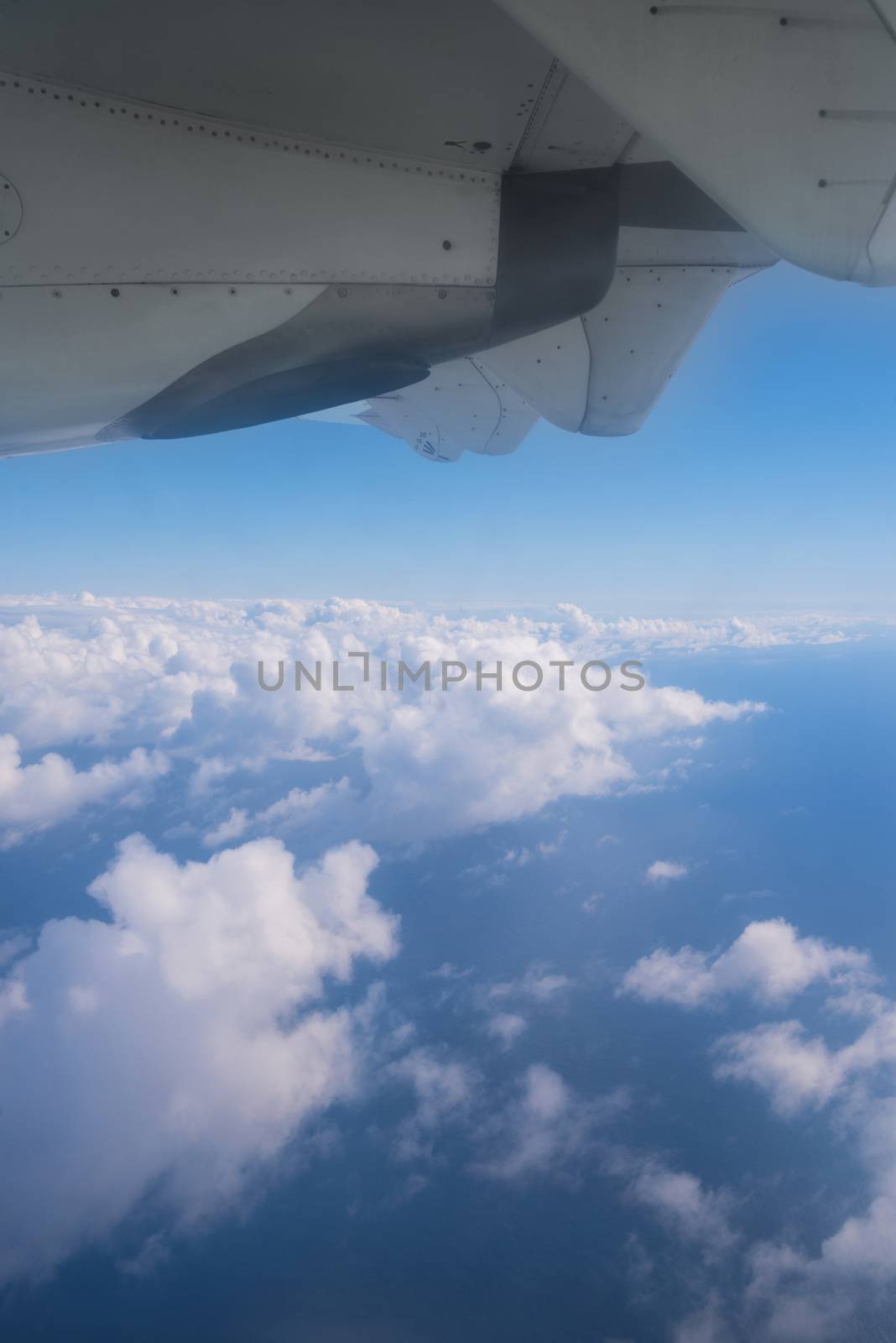 View of the clouds and the ocean from the airplane window.