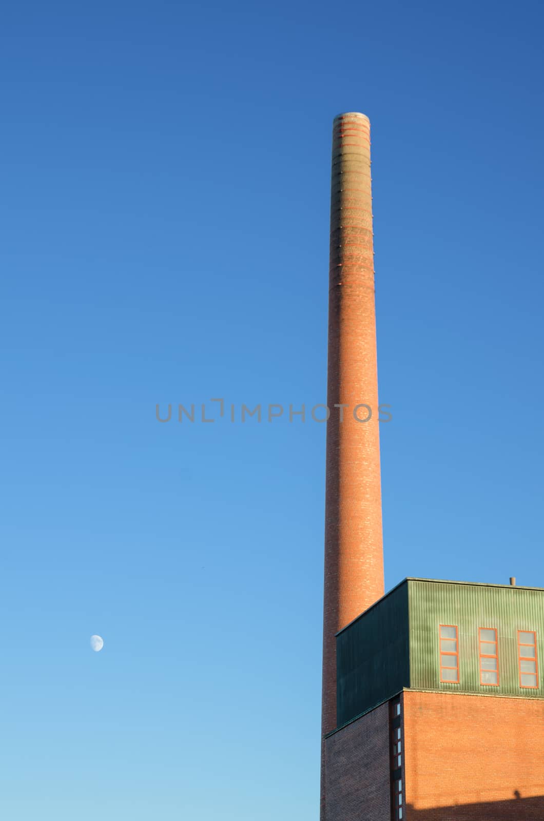 Industrial brick chimney at dusk.