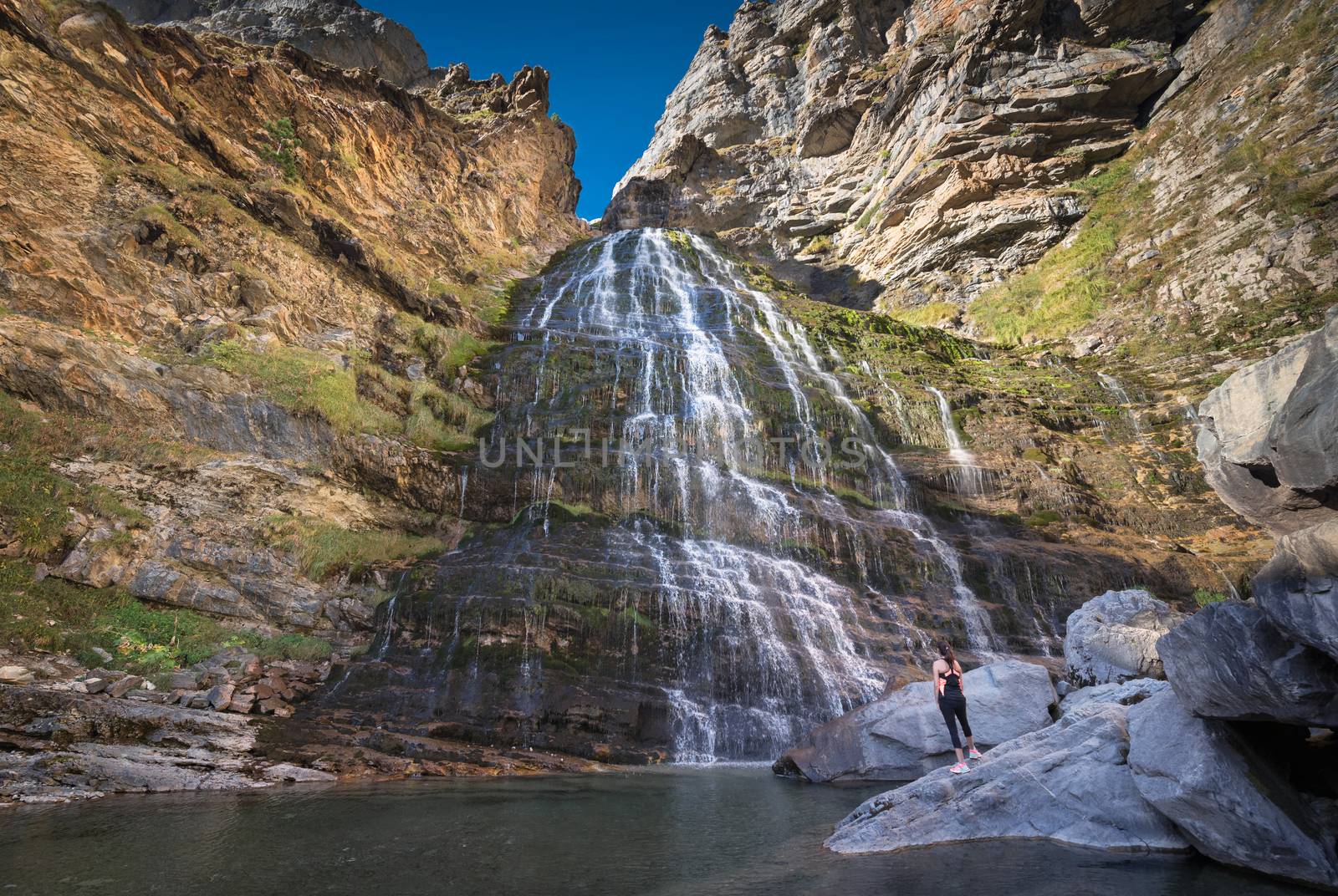 Hikker womann looking at Horsetail waterfall in Ordesa national park, Pyrenees, Spain.