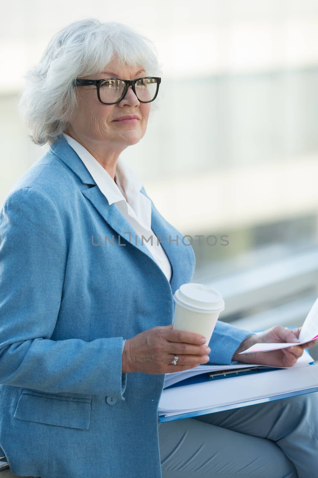 Senior business woman at coffee break with documents