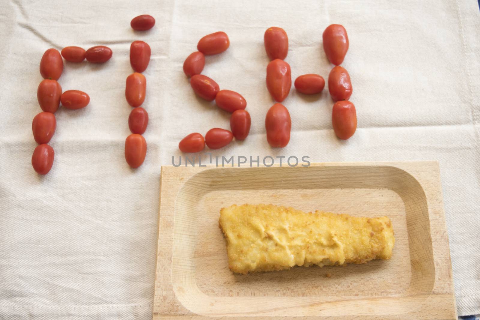 fried fish burger with near the written fish made with pachino tomatoes