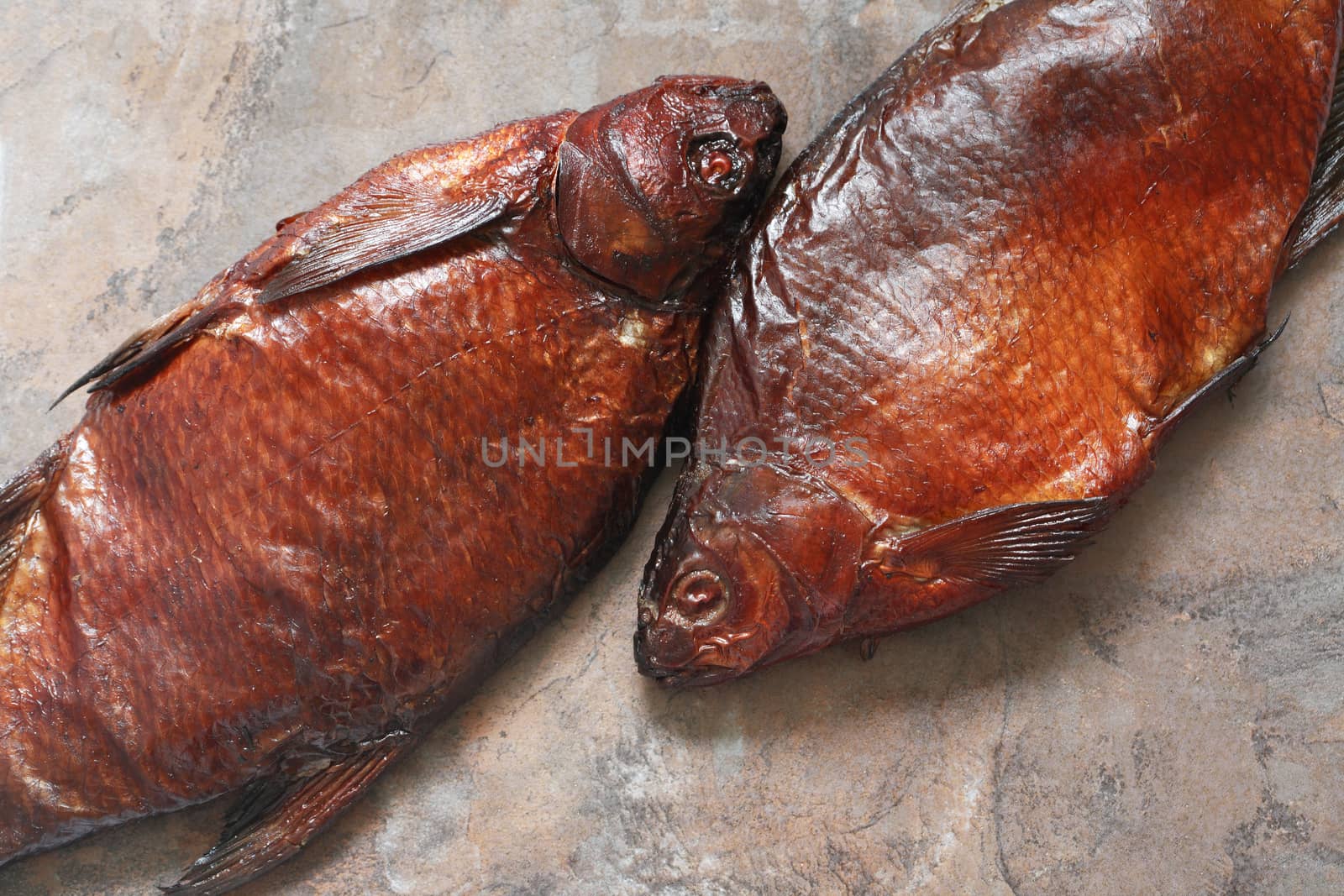 Closeup of two freshness smoked fishes on stone background