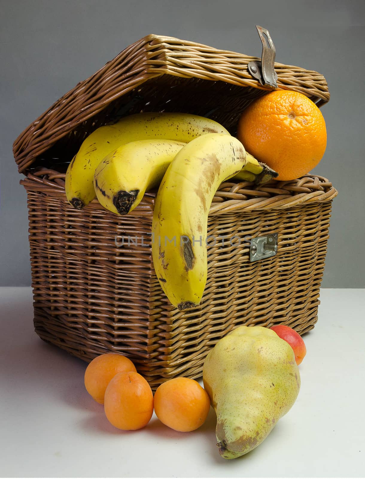 Picnic basket with fruits, orange, pear and apricot banana