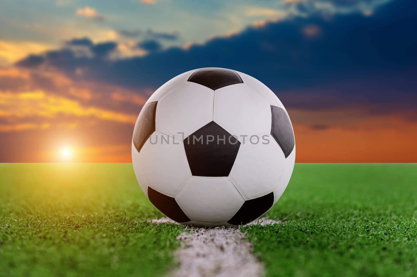 soccer ball on soccer field at sunset.